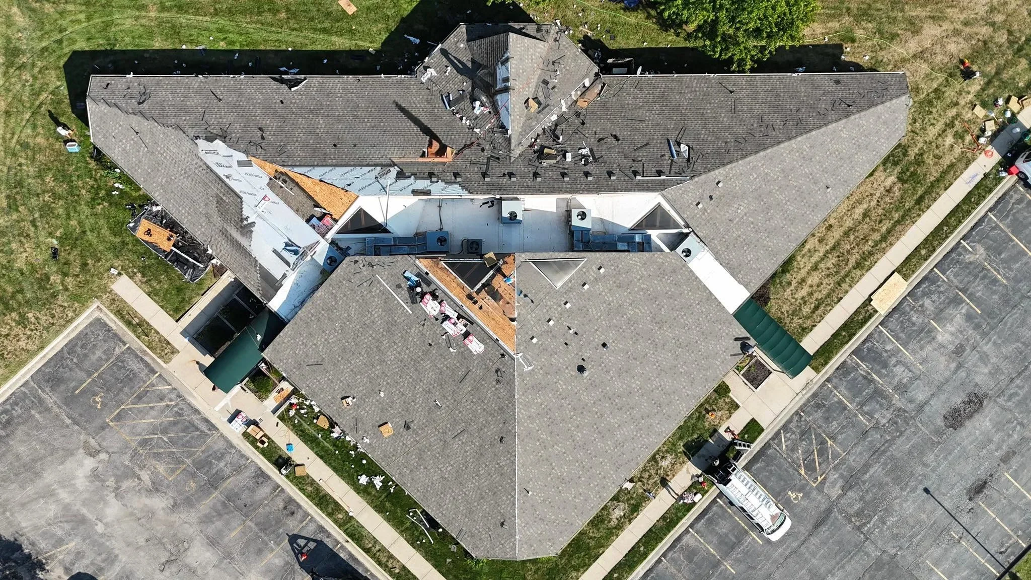 Aerial view of residential roof replacement with gray architectural shingles and white trim