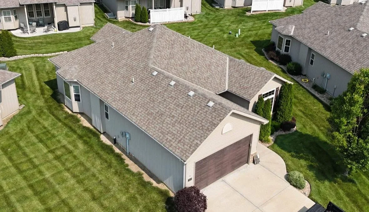 New asphalt shingle roof installation with charcoal gray shingles and roof vents on residential home