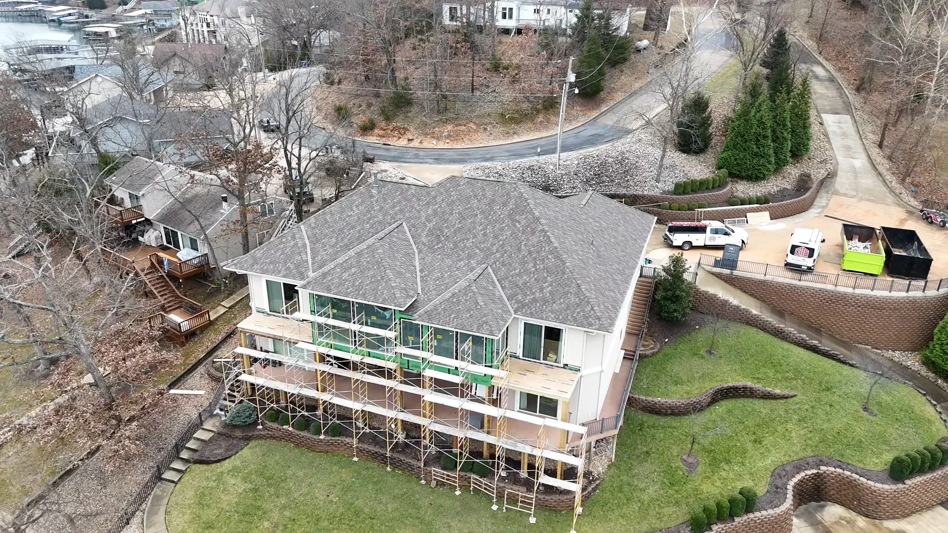 Aerial view of residential home with new gray architectural shingle roof installation in progress